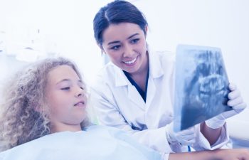 Dentist showing a patient an xray of teeth at the dental clinic